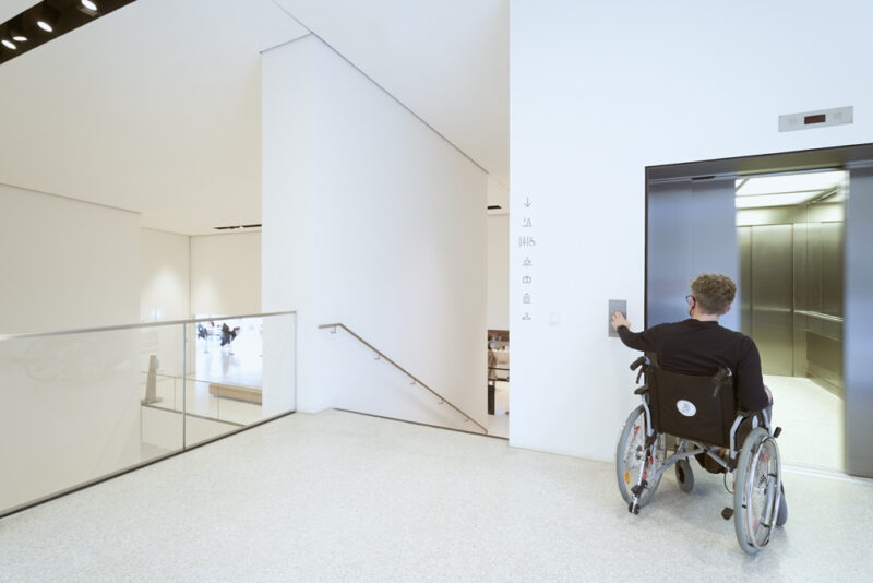 Fahrstuhl | Foto: Nikolaus Frank Ein Mann im Rollstuhl öffnet die Fahrstuhltür im 1. OG
