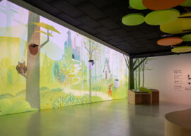 06 | IMMERGRUEN | © GRIMMWELT Kassel | Foto: Nicolas Wefers Bild zeigt den ganzen Raum mit Märchenwaldprojektion an der Wand und den drei Stempelstationen