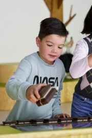 02 | IMMERGRUEN | © GRIMMWELT Kassel | Foto: Nicolas Wefers Ein Junge steht an der Stempelstation und hält einen virtuellen Stempel in der Hand.