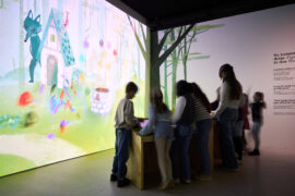 04 | IMMERGRUEN | © GRIMMWELT Kassel | Foto: Nicolas Wefers Kinder stehen im Raum an den Stempelstationen und erstellen mit virtuellen Stempeln eigene Figuren