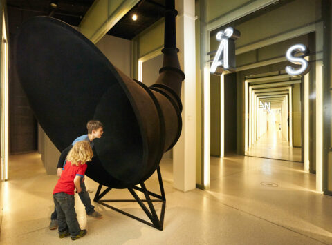 Ä | ÄRSCHLEIN | Foto: Nikolaus Frank Zwei Kinder beim Schimpfworttrichter in der GRIMMWELT.