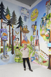 03 | Sonderausstellung unMÖGLICH | Die Magie der Wünsche | Foto: Nicolas Wefers Jim Avignon vor seinem bunten Wandbild in der Sonderausstellung unMÖGLICH