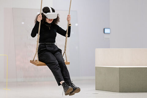 Sonderausstellung unMÖGLICH | Die Magie der Wünsche | Foto: Sascha Mannel Frau mit VR-Brille, sitzt auf Schuakel in der Sonderausstellung