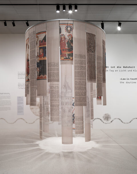 Sonderausstellung AKTE RUMPELSTILZCHEN | Volksgeist | Foto: Nicolas Wefers Installation des Volksgeist mit bedruckten Stoffbahnen die von der Decke hängen