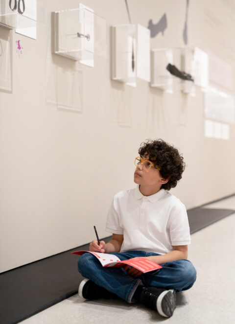 Sonderausstellung AKTE RUMPELSTILZCHEN | Rätselspur | Foto: Nicolas Wefers Junge sitzt auf Boden und bearbeitet die Rätselspur