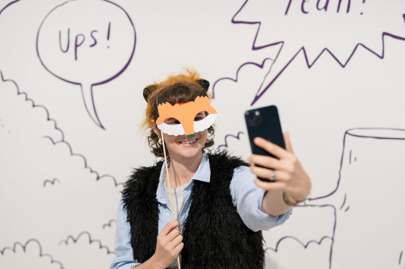 Ausstellung ICH, DAS TIER | Werde zum Tier | © GRIMMWELT Kassel, Foto Nicolas Wefers Verkleidete Frau als Wolf in der Selfi-Mitmach-Station