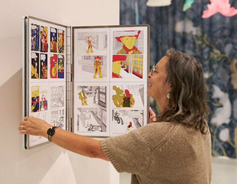 Sonderausstellung ZWISCHEN GESTALTEN. HELGA GEBERT | Foto: Nicolas Wefers Frau schaut und blättert in einem übergroßen Buch