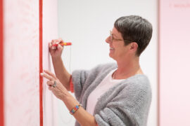 13 | Sonderausstellung unMÖGLICH | Die Magie der Wünsche | Foto: Sascha Mannel Frau beschriftet Tafeln mit Ihren Wünschen