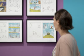 15 | Ausstellung ICH, DAS TIER | Josephine Mark | © GRIMMWELT Kassel, Foto Nicolas Wefers Frau schaut sich Illustrationen von Josephine Mark an