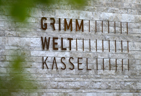 04. GRIMMWELT Kassel | Ein Publikumsmagnet in Nordhessen, der Heimat der Brüder Grimm. Grimmwelt Logo an der Fassade des Gebäudes