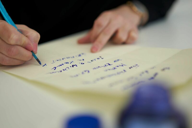 Workshop FROTEUFEL | Foto: Nikolaus Frank Ein Brief wird mit Feder und Tinte per Hand geschrieben.