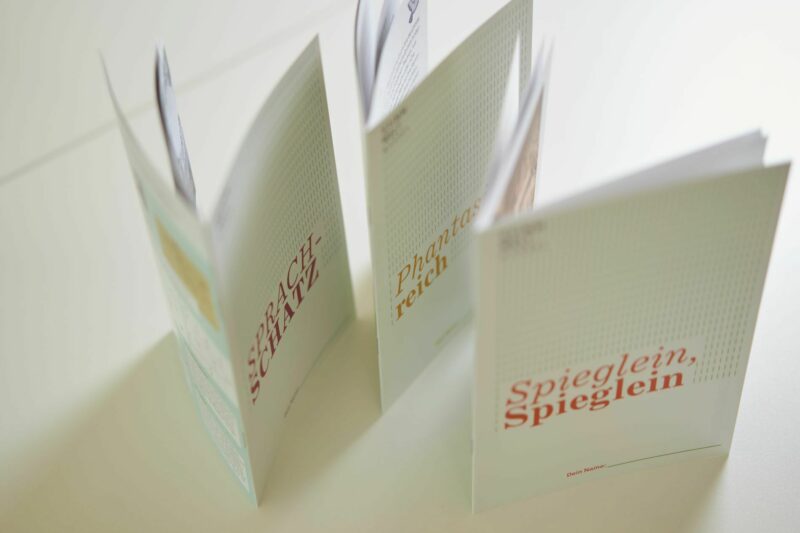 GRIMMWELT Kassel | Dauerausstellung | Begleithefte | Foto: Nikolaus Frank Bild der drei Schüler*innenbegleithefte für den Besuch der Dauerausstellung.