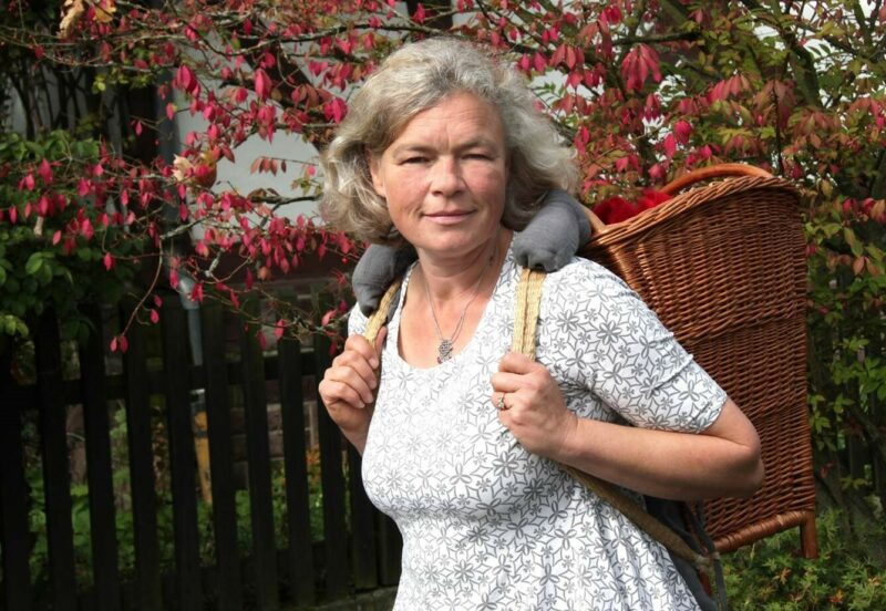Storyteller Gudrun Rathke | Photo: Nicola Uphoff Watschong The photo shows the storyteller Gudrun Rathke with a wicker basket on her shoulders.